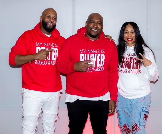 Three watchmen in My Name Is Prayer hoodies — red and white